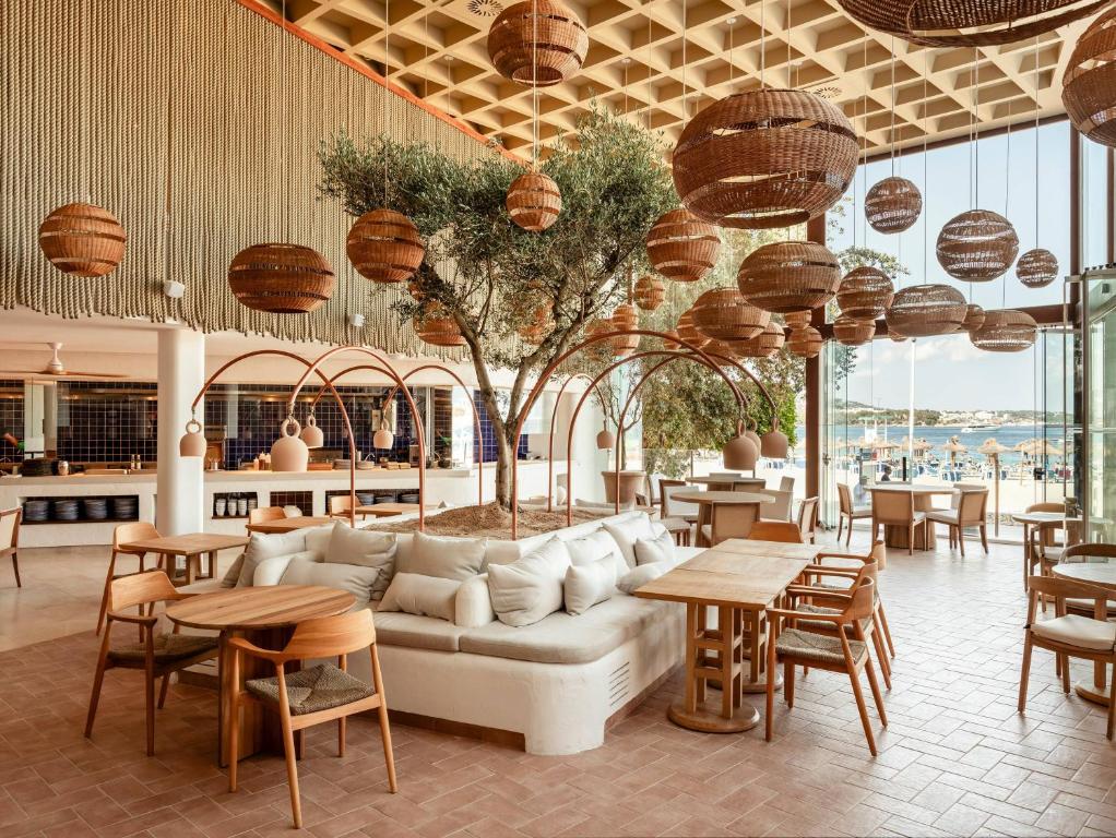 ein Wohnzimmer mit Sofa, Tischen und Stühlen in der Unterkunft Zel Mallorca in Palmanova