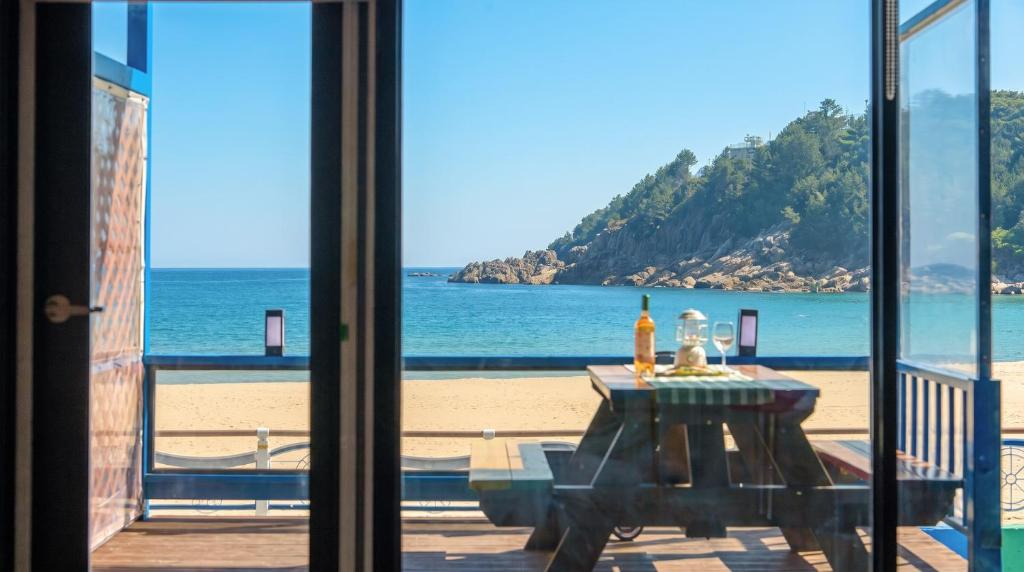 a view of the beach from a room with a table at Goseong CNBLUE Oceanview Pension in Goseong