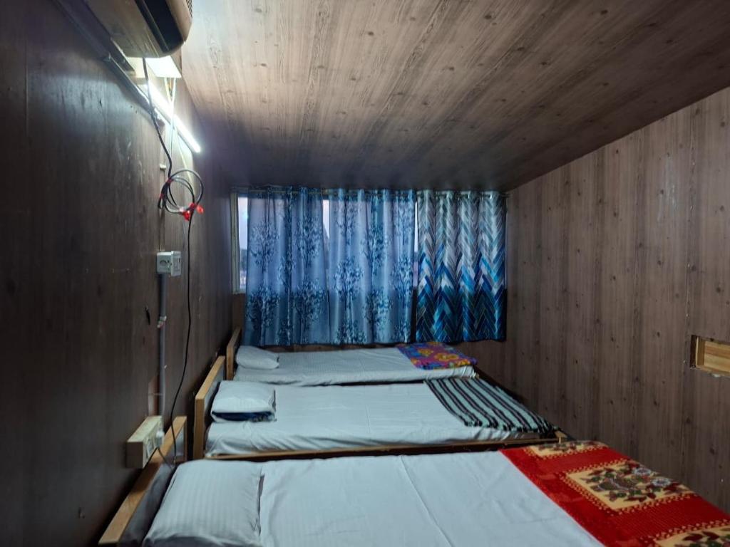 a bedroom with two beds and a window at Terrace Camp inn in Tiruchirappalli