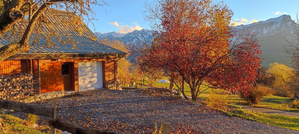 a small house in the middle of a field with trees at Chalet Mounette Ski Sauna Lac Embrun in Puy-Sanières