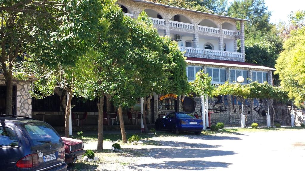 una casa con coches aparcados delante de ella en Guesthouse Mala Venecija en Virpazar