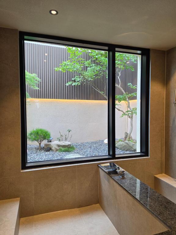 a bathroom with a large window with a garden outside at 목포 미유스위트 호텔 in Taeban-dong