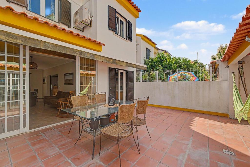 a patio with a glass table and chairs in a house at Azeitão Town House in Azeitao