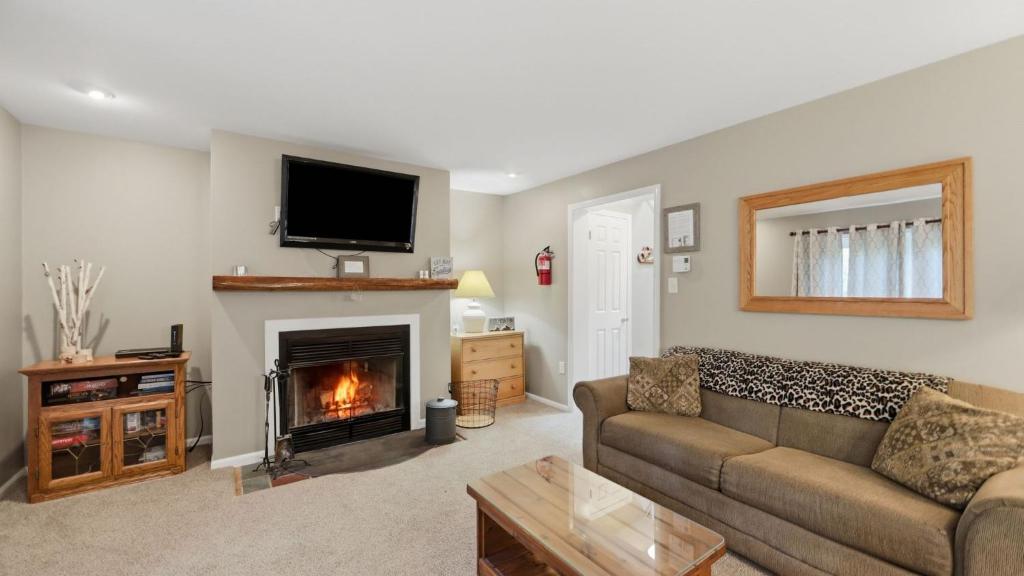 a living room with a couch and a fireplace at Fox Lair by AvantStay in North Creek