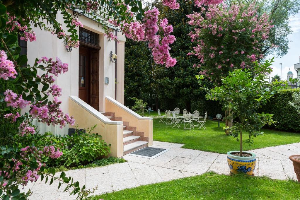 una casa con flores rosas en el patio en Residence Villa Mainard, en Verona