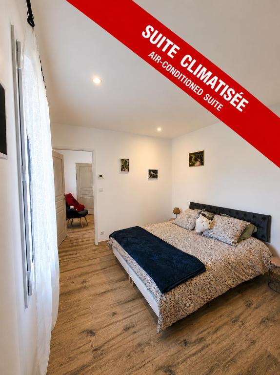 a bedroom with a bed with a red sign above it at Le Clos des Elfes - suite climatisée in La Roque-Gageac