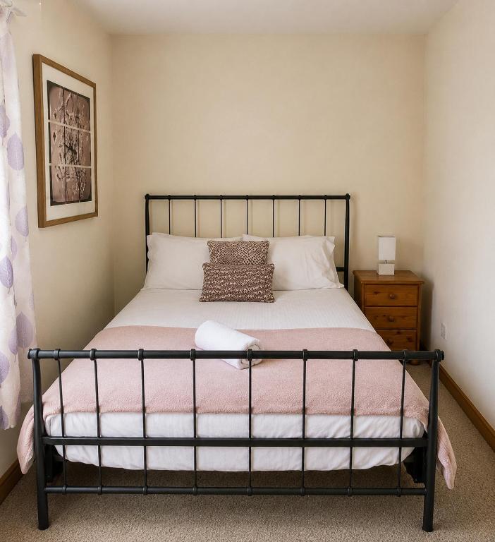 a bedroom with a bed with a black frame at 54 - Room 3 - City views in Swansea