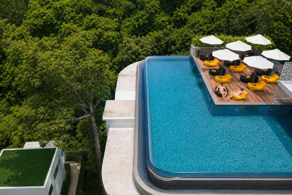 an overhead view of a swimming pool with chairs and umbrellas at Relax, Swim & Stay Active in this Duplex - UTL B131 in Rawai Beach