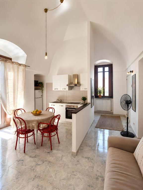 a kitchen and living room with a table and chairs at La Dimora del Colle in Mottola