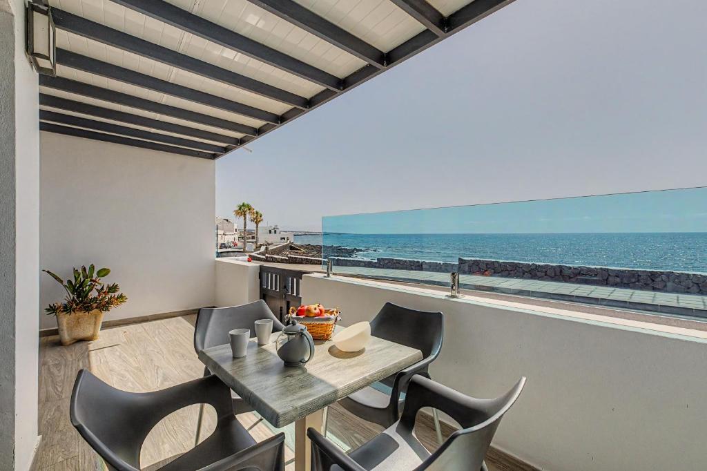 a dining room with a table and chairs and the ocean at Callao Beach 2 in Arrieta