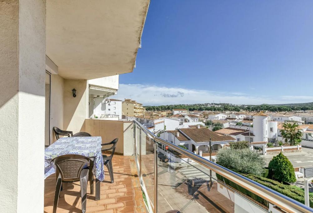 a balcony with a table and chairs and a view of a city at Escala Riells in L'Escala