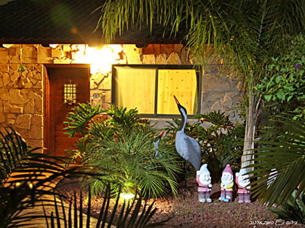 a garden with a bird and some plants and a building at A Place Of The Heart in Liman