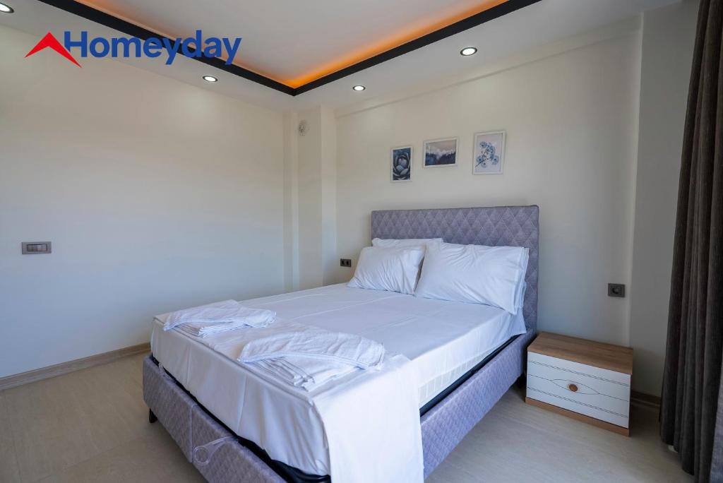 a bedroom with a bed with white sheets at Villa Elyse & Paradise in Orta
