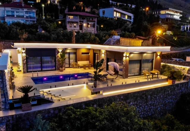 a large house with a swimming pool at night at Vatër by the lake in Shirokë