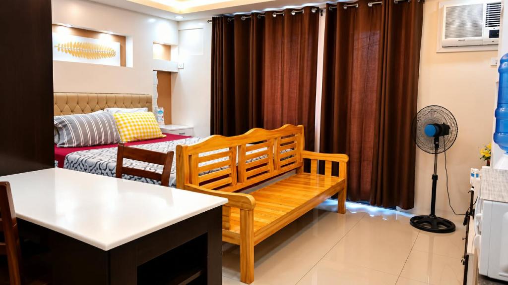 a living room with a bench and a couch at Italian Inspired Tropical-Themed Studio Condo in Davao City