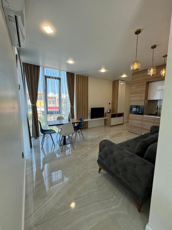 a living room with a couch and a table with chairs at ANDE Apartments Hotel in Gonio