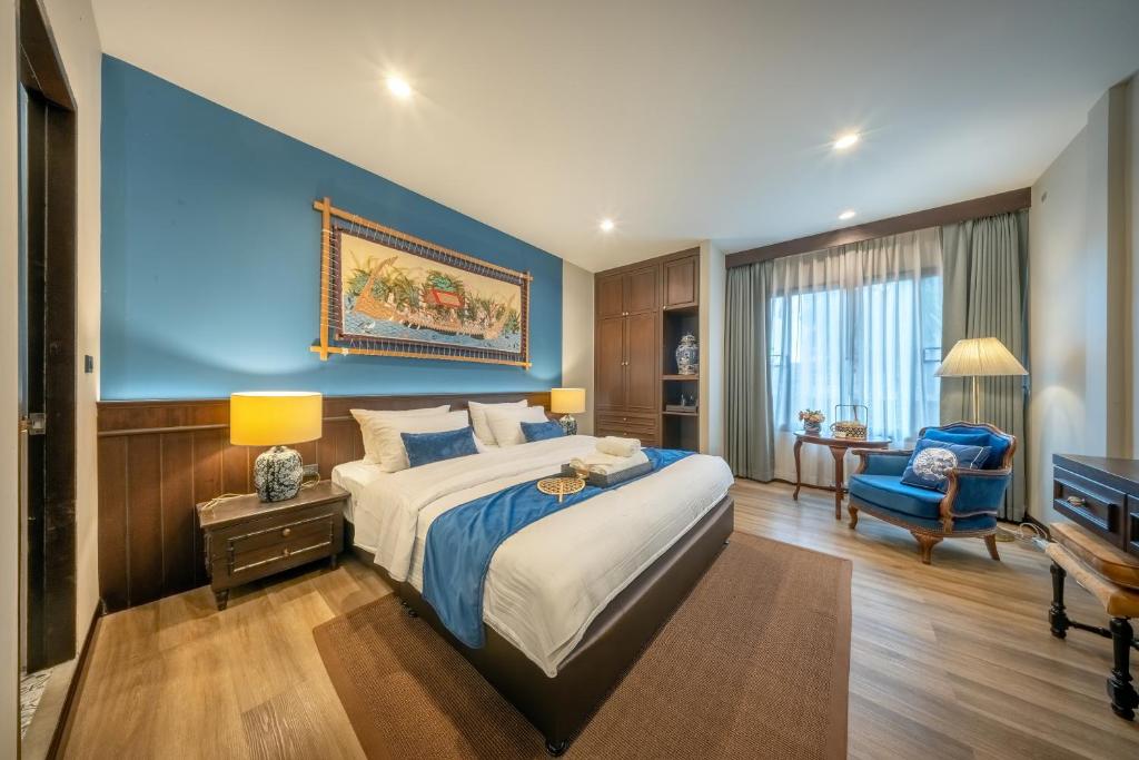 a bedroom with a large bed and a blue wall at Apirom Hometel in Sathani Lak Si