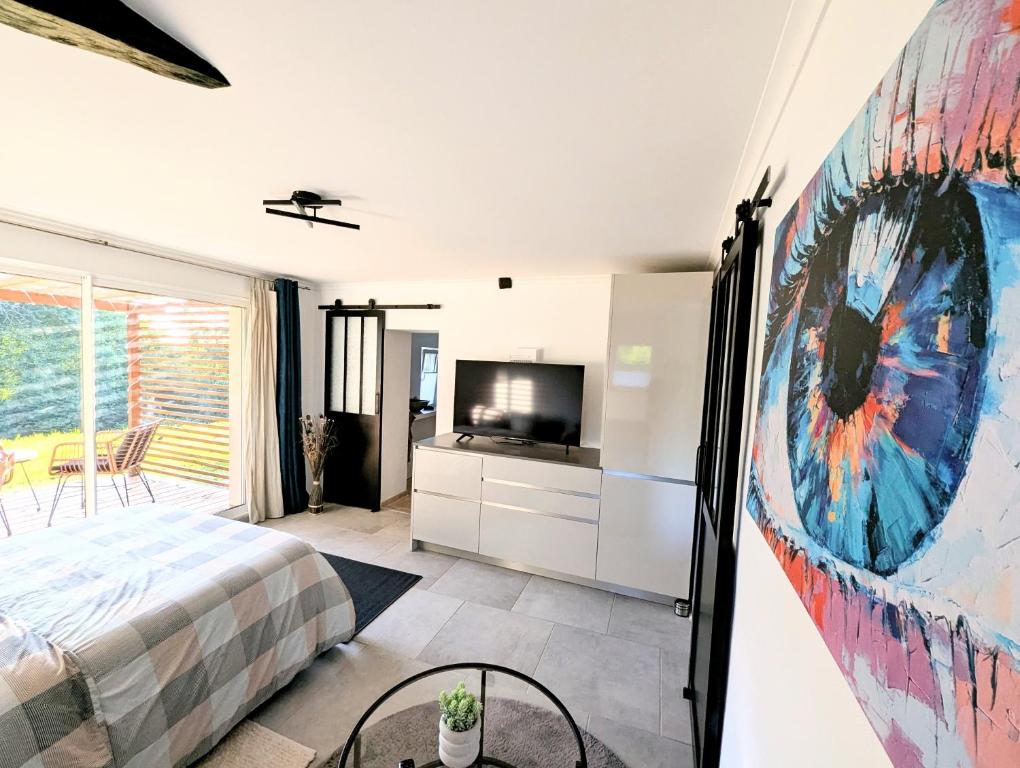 a bedroom with a bed and a tv and a painting at Tranquillity in a modern unit in Bazugues