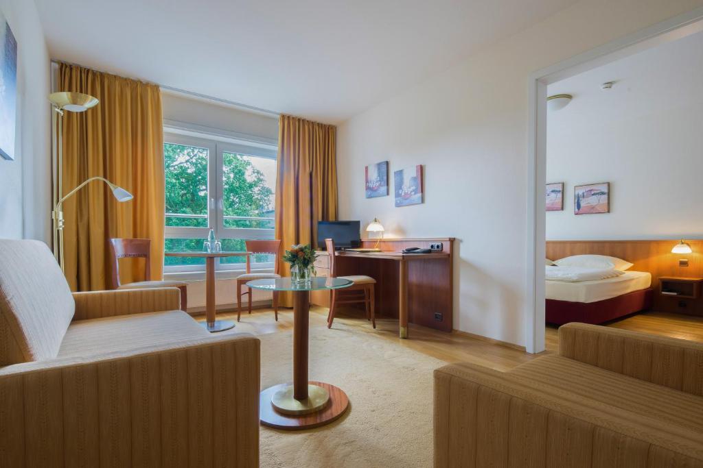 Habitación de hotel con sofá y cama en NewLivingHome Residenzhotel Hamburg, en Hamburgo