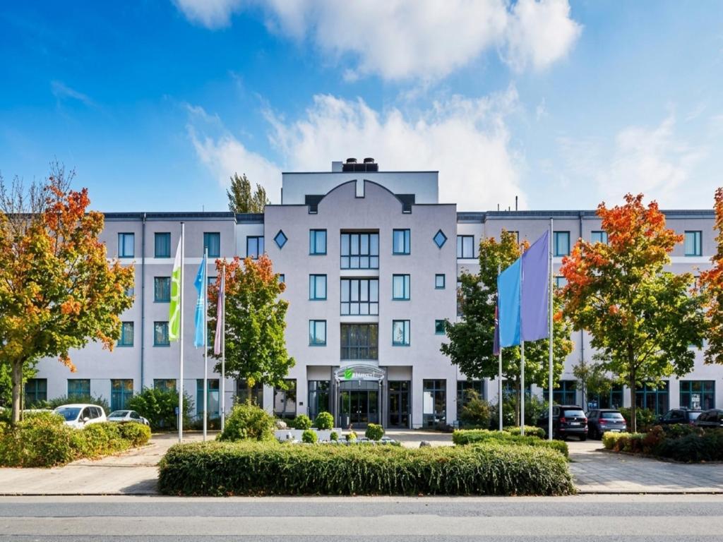 an office building with flags in front of it at Sunday Hotel Hannover in Hannover