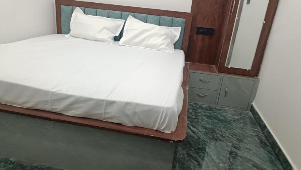 a bedroom with a white bed and a mirror at Hotel Kunj Palace in Etah