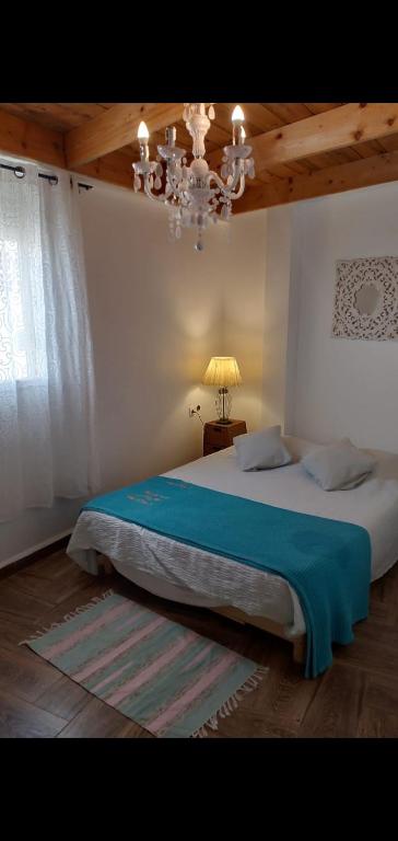 a bedroom with a large bed and a chandelier at Marina in Tipaza