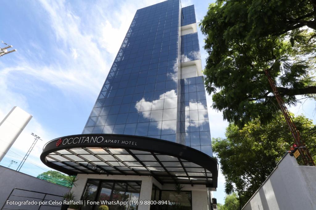 a tall building with a sign in front of it at Occitano Apart Hotel in Piracicaba