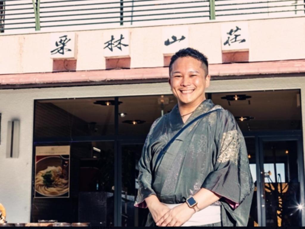 a man standing in front of a building at 旅館御宿Tabist Ritsurinsanso in Takamatsu