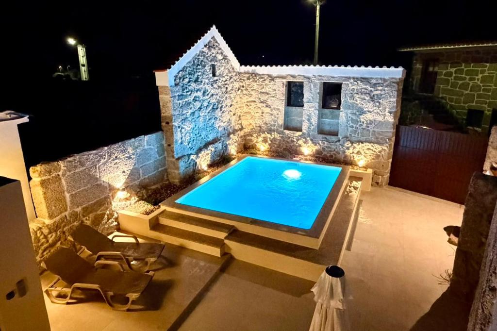 a swimming pool on a patio at night at Casa do Largo do Cruzeiro in Vouzela