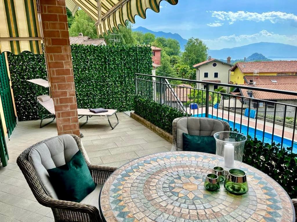 a patio with a table and chairs and a view of a pool at Appartamento La Perla in Brezzo