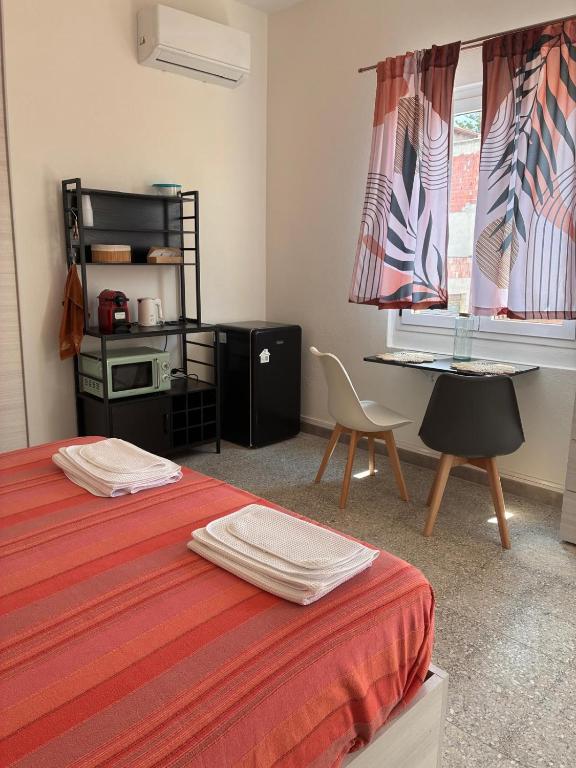 a room with two beds and a desk and a window at Nonna Consolata Studio - 25 min to Cagliari & Beaches in Dolianova