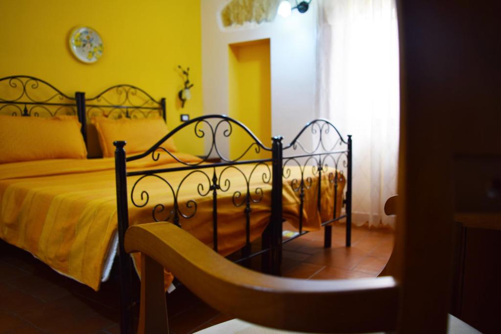 um quarto com uma cama preta e paredes amarelas em B&B Salotto Di Athena em Agrigento
