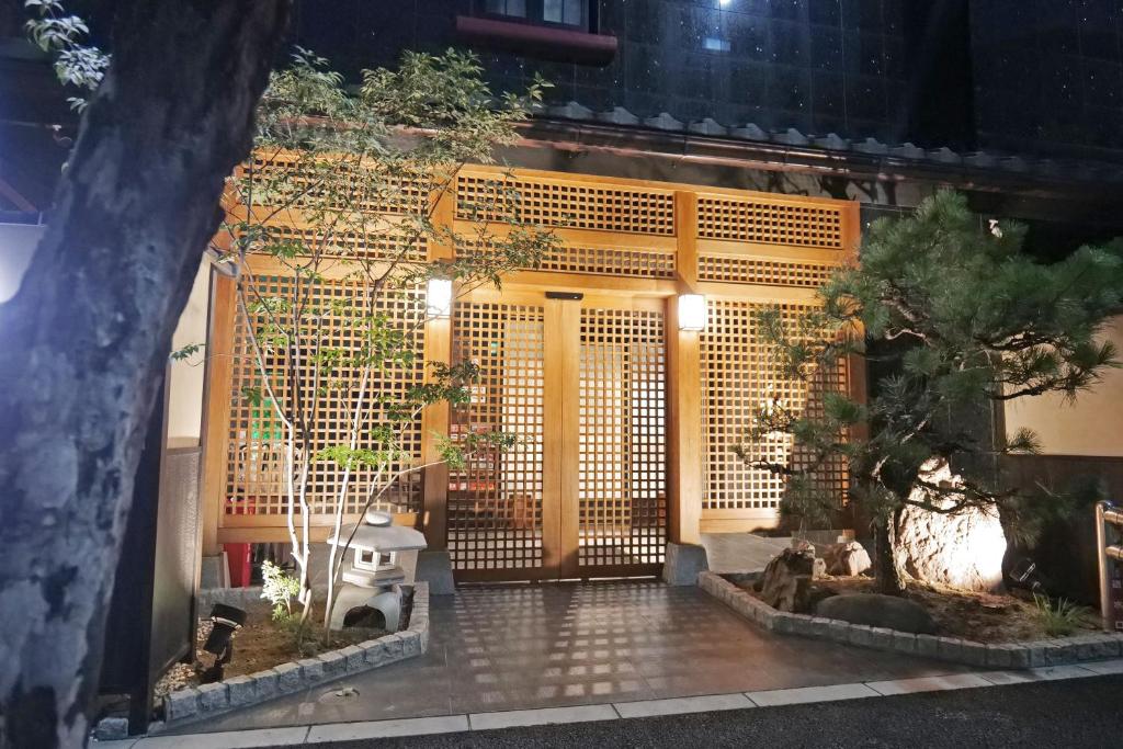 a building with a gate with trees in front of it at Petit Grande Miyabi in Tokyo