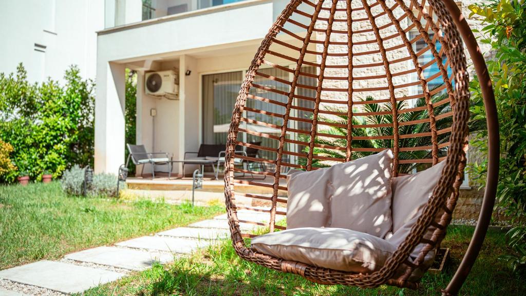 a swing chair in a yard in front of a house at Garden View Apartment in Rrushkull