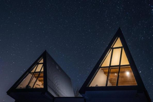 a building with two windows in the night sky at Engadin Mountain Kucica in Brda