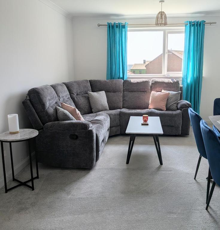 a living room with a couch and a table at Mach House in Campbeltown
