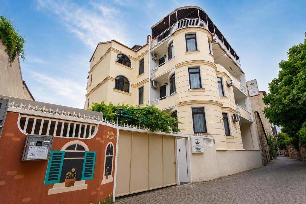 a large yellow building with a garage at Hotel Imperial House in Tbilisi City