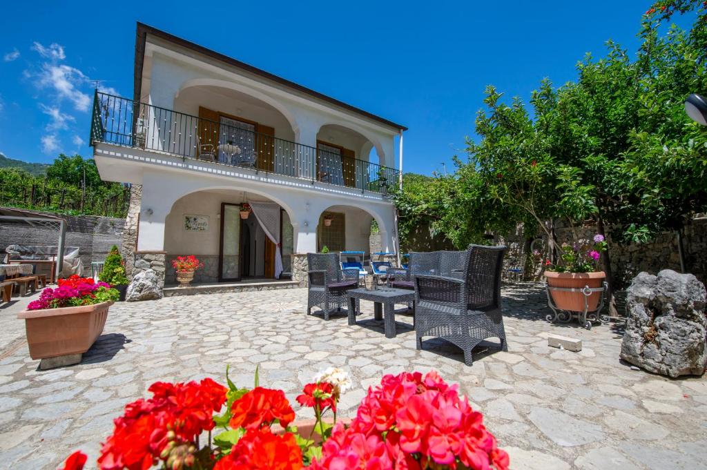 a patio of a house with red flowers at Il Vigneto in Tramonti