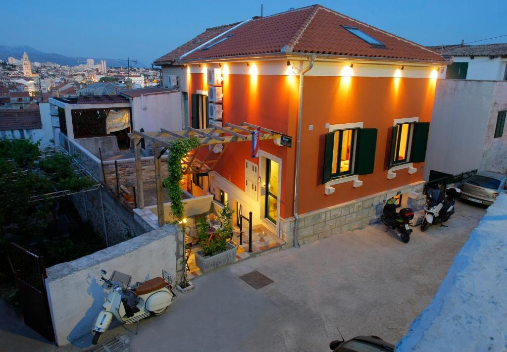uma casa laranja com motos estacionadas em frente em Villa Urbi et Orbi em Split