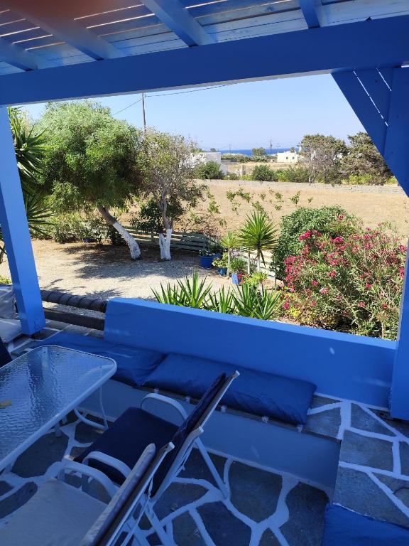 a blue bench with two chairs and a table at Villa Lena in Kastraki