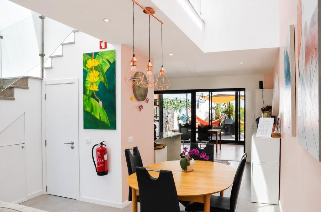 a kitchen and dining room with a table and chairs at Casa Elegante V3 Moderna 2 Suítes, Jardim e Garagem Privados in Olhão
