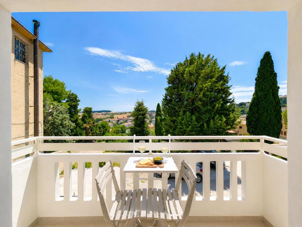 a white balcony with a table and chairs on it at Konero Room in Loreto