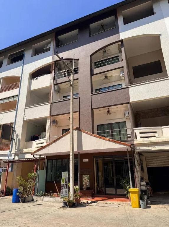an apartment building with a street light in front of it at Orient Hotel in Jomtien Beach