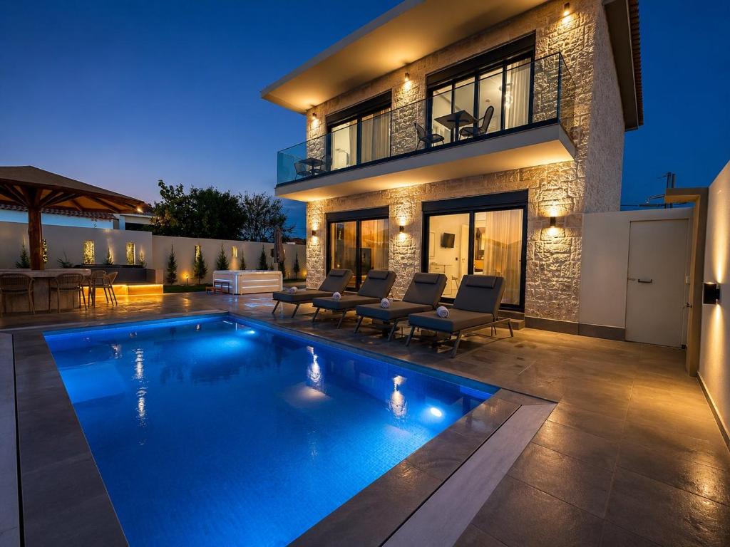 a swimming pool in front of a house at Amfi Luxury Villa 4BR with Private Pool by Villa Mana Gers in Sarakinádhon