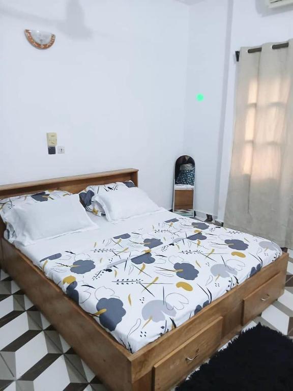 a bed in a room with a bedskirtspectspectspects at Home Appart in Porto-Novo
