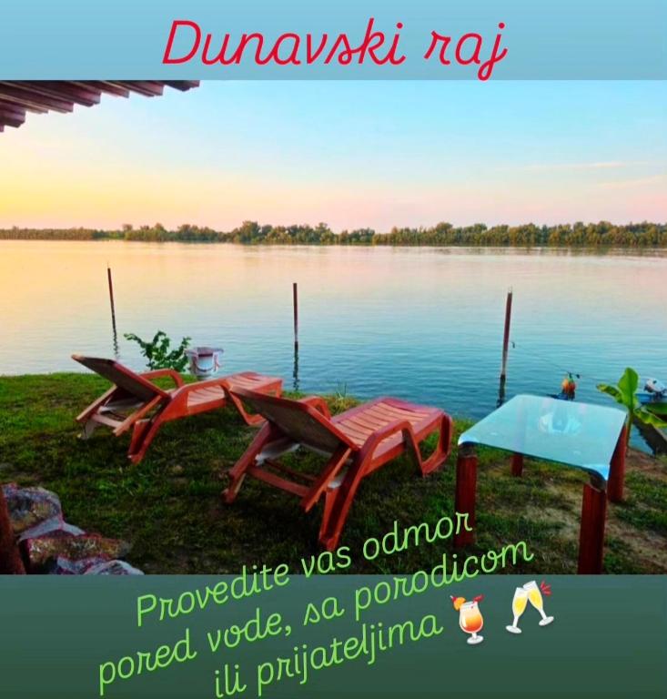 a picture of a lake with two picnic tables at Dunavski Raj in Belgrade