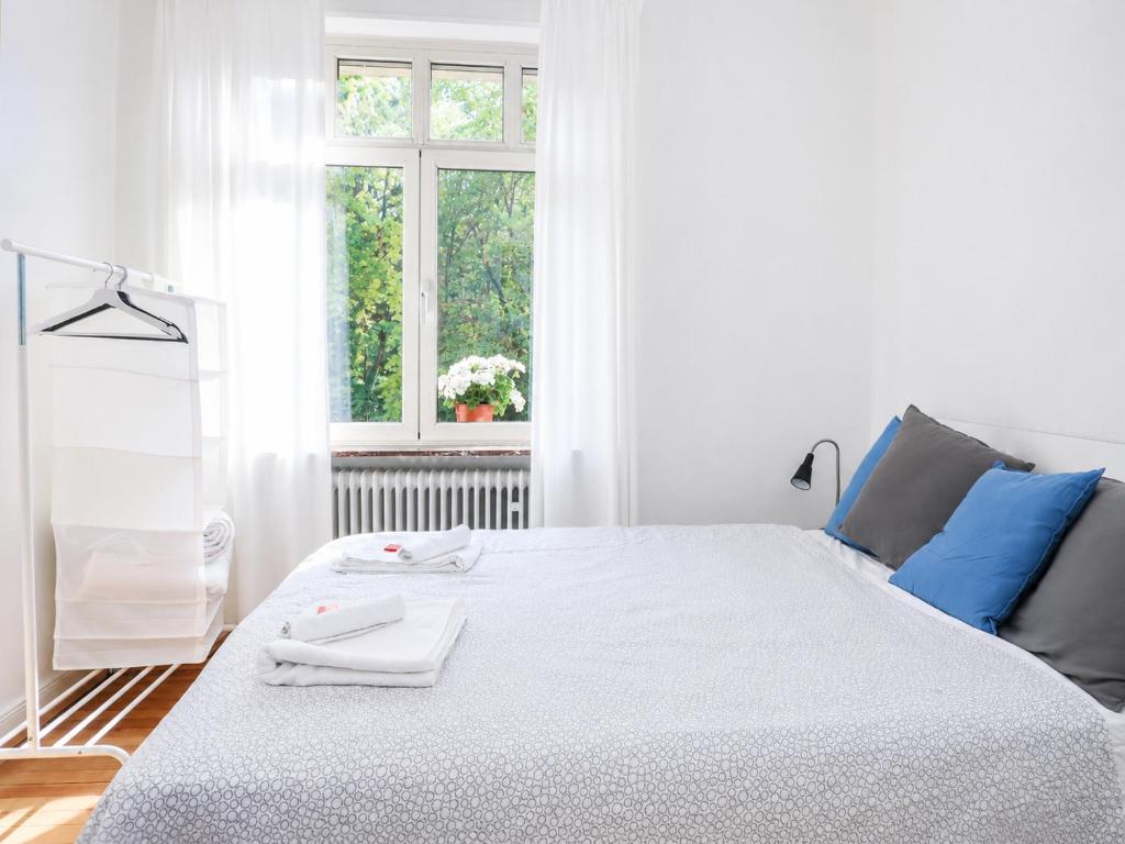 a white bedroom with a large white bed with a window at rooms lux city in Luxembourg