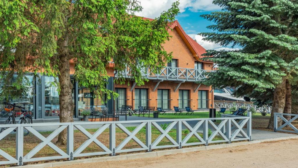 a house with trees in front of it at Marina Piaski Apartamenty in Piaski