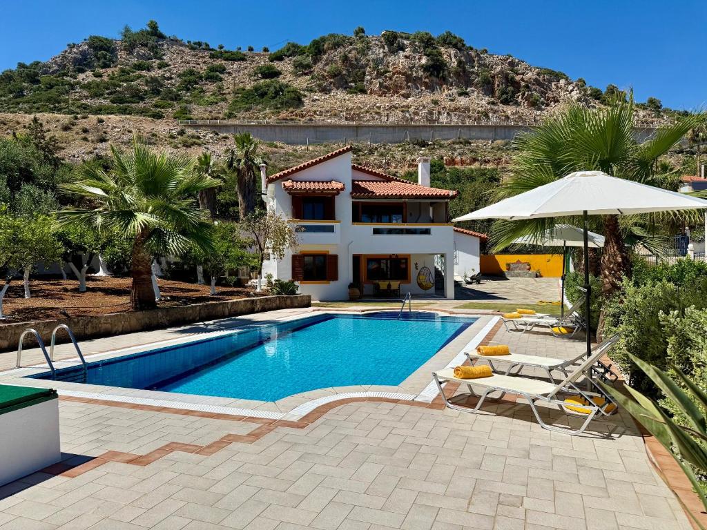 a villa with a swimming pool and a house at Villa Lemonia in Malia