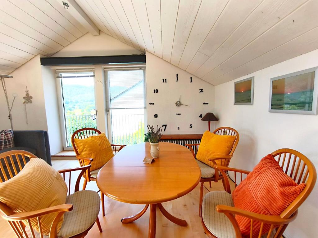 a dining room with a table and chairs and a clock at Panoramablick Loft & Aktiv-Urlaub in Lichtenstein